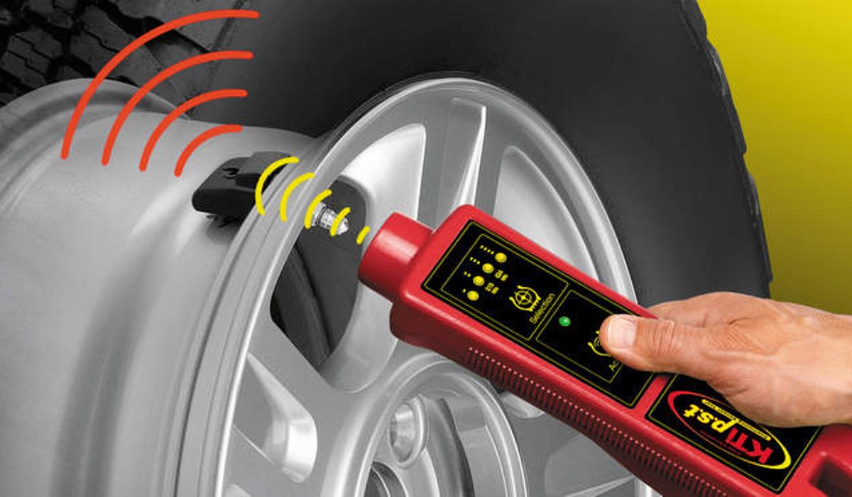  Image of Tire Pressure Monitor tool reading the sensor inside the tire representing TPMS diagnosis. 